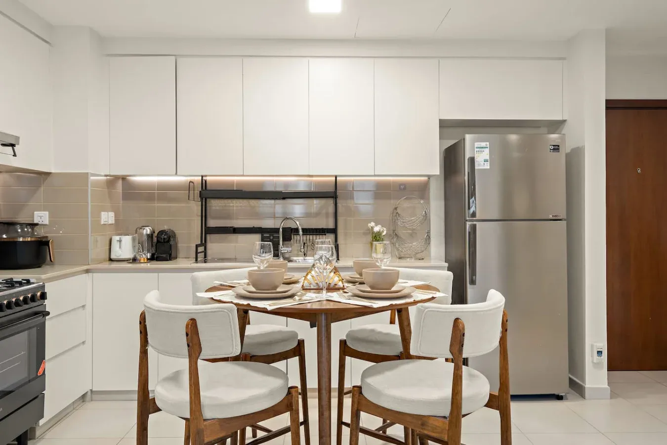 A bright kitchen and dining area with a table set for a meal.