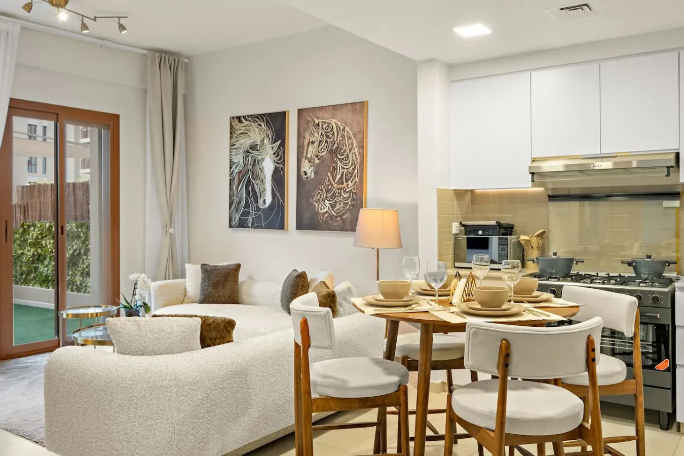 A bright living and dining area opens into a modern kitchen, with artwork on the wall.