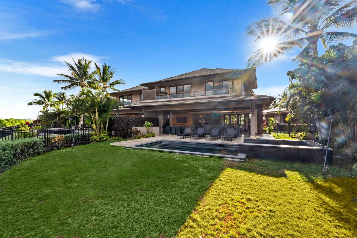 Una casa moderna da a un césped y un patio con piscina.