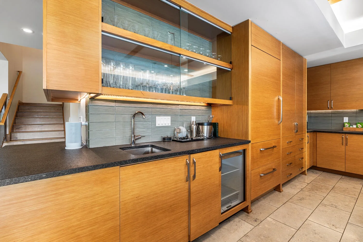 Una cocina moderna con gabinetes de madera, una encimera y un fregadero.