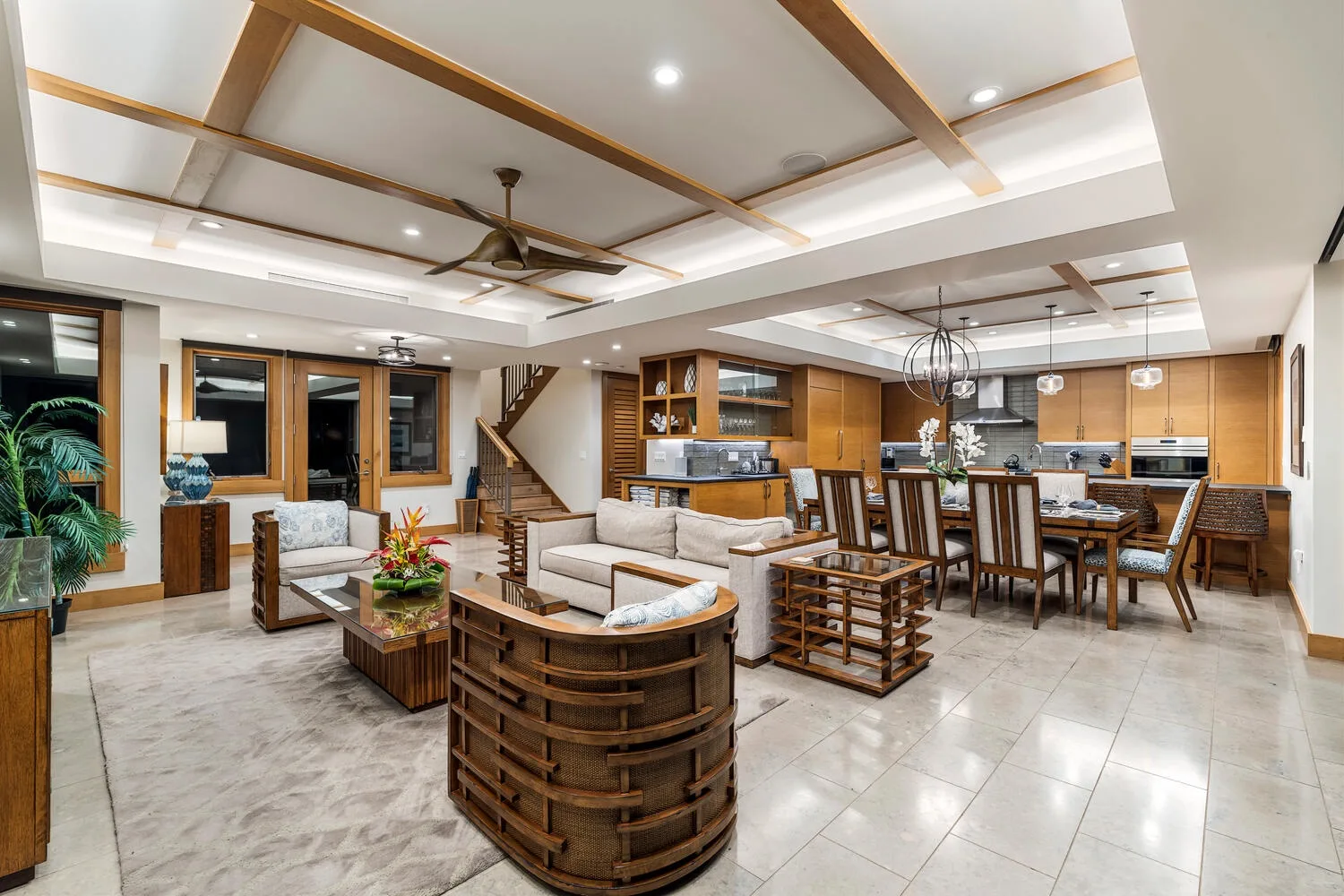 Una sala-comedor de concepto abierto con cocina y asientos de tonos claros.