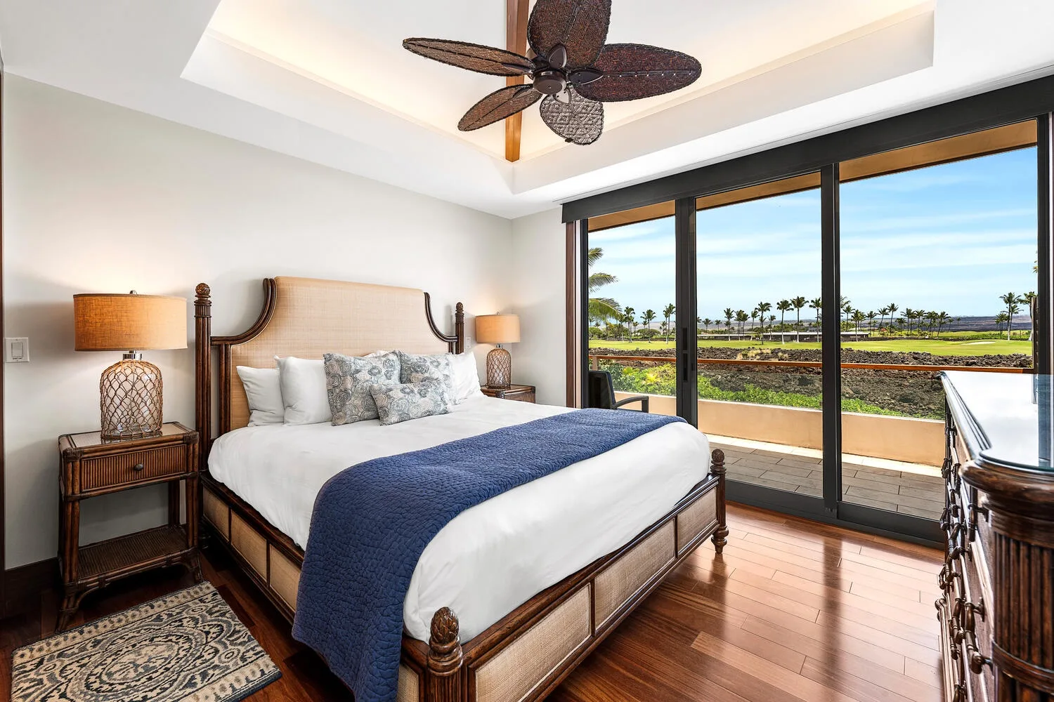 Un dormitorio con una cama junto a grandes puertas de vidrio que dan a un balcón.