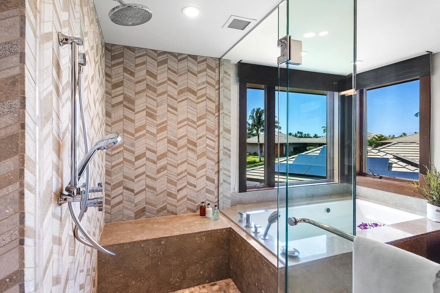 Un baño con una ducha de vidrio junto a una ventana grande.