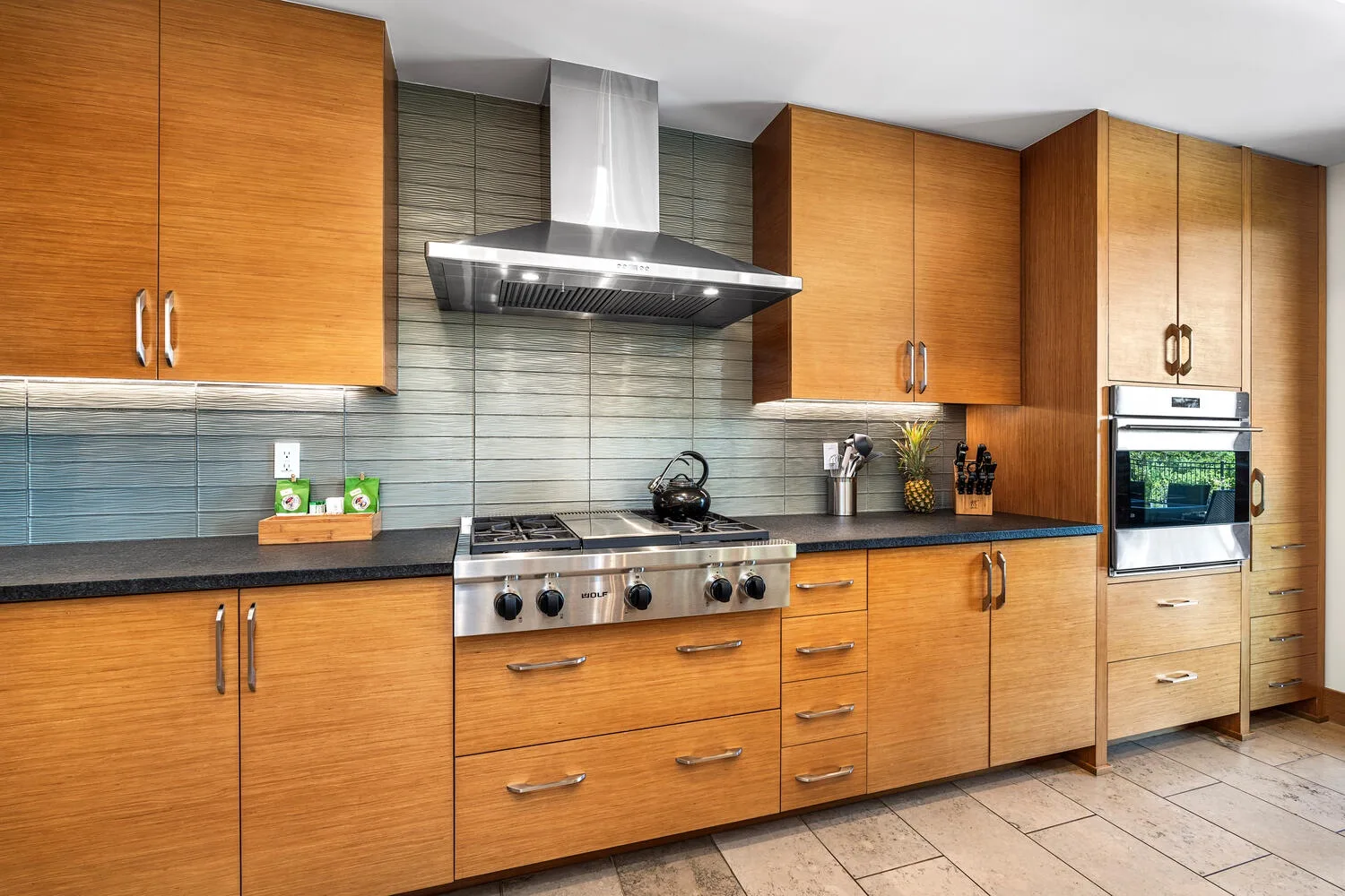 Una cocina con gabinetes de madera, una placa de cocina y una campana extractora.