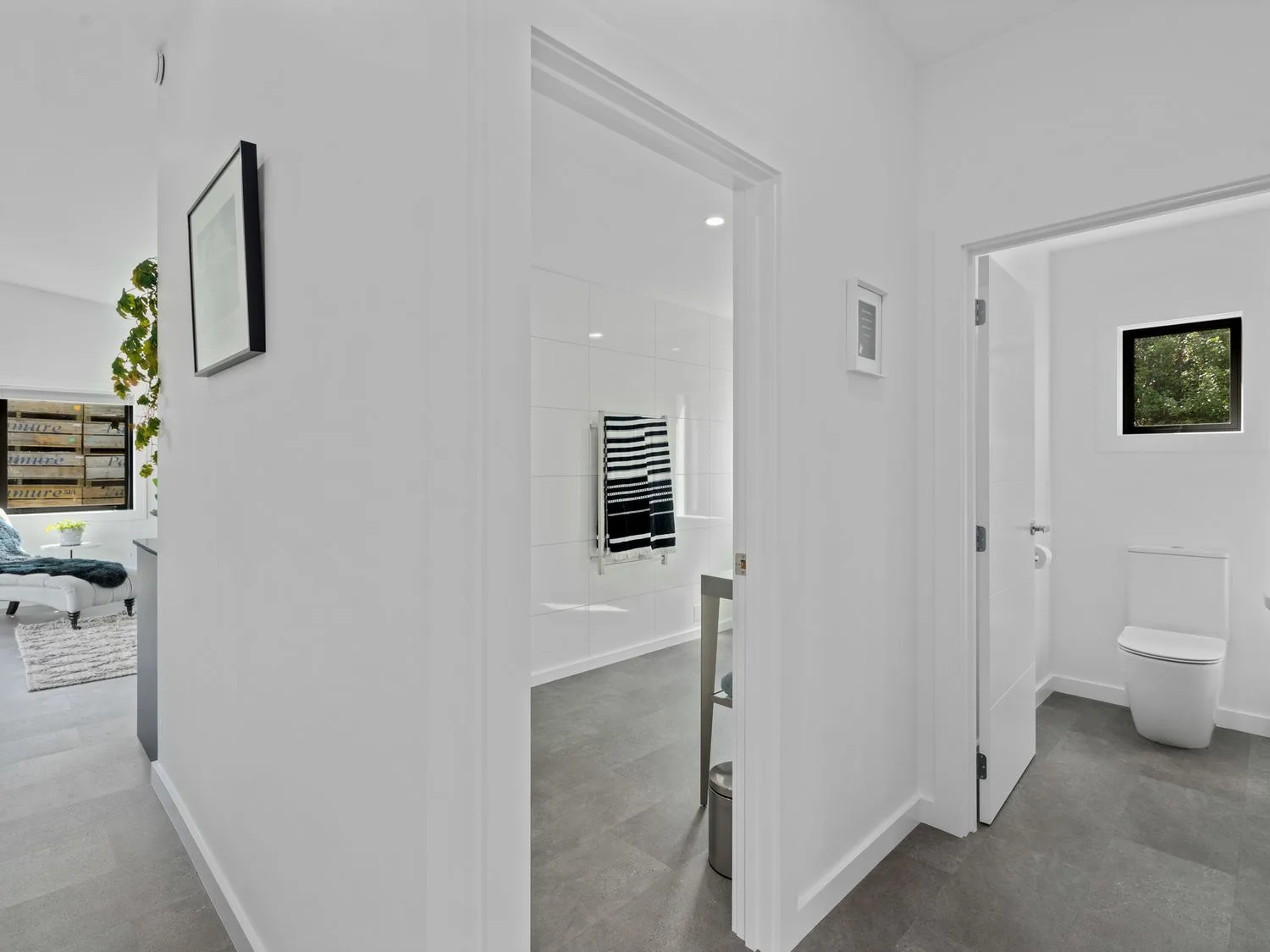 Un pasillo con dos puertas abiertas que dejan ver un baño con un inodoro y una habitación con toallas colgadas en Caledonia - Earnscleugh Holiday Home, en Earnscleugh