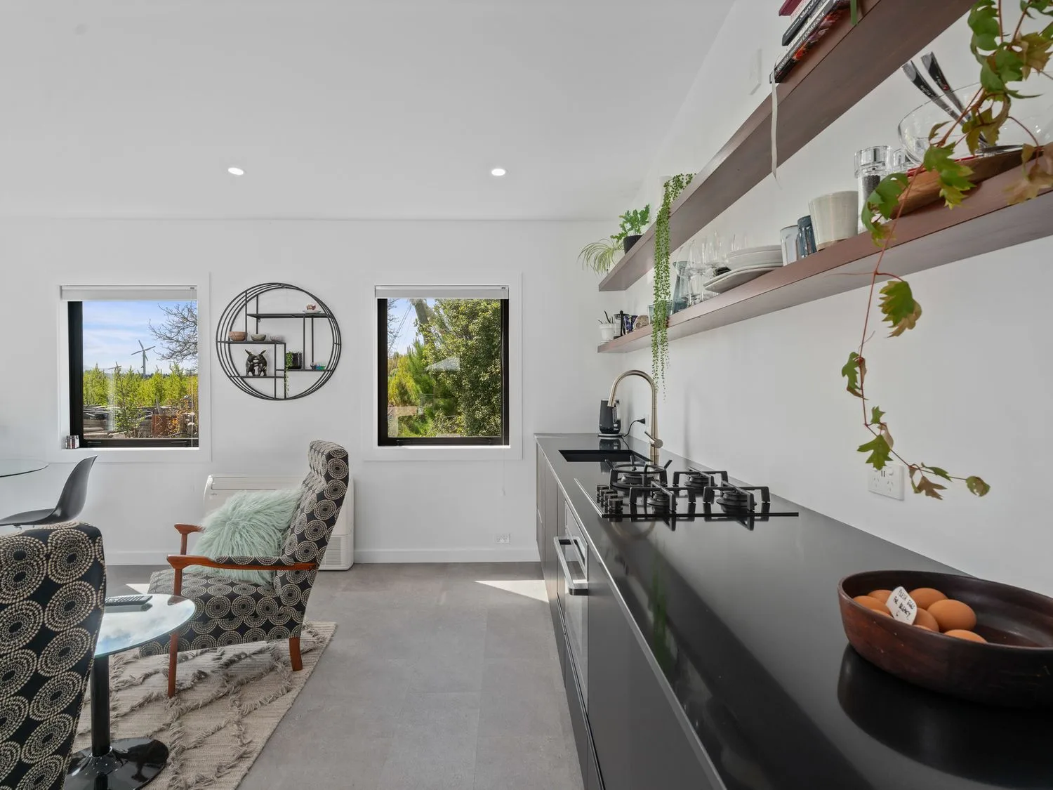 Una cocina y zona de comedor con encimera negra y sillas estampadas en Caledonia - Earnscleugh Holiday Home, en Earnscleugh