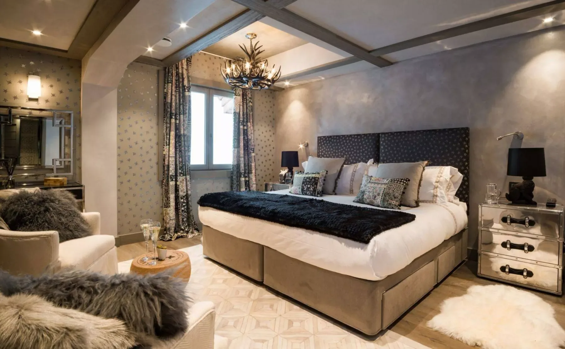 Un dormitorio con una cama grande, un cabecero tapizado y una zona de estar.