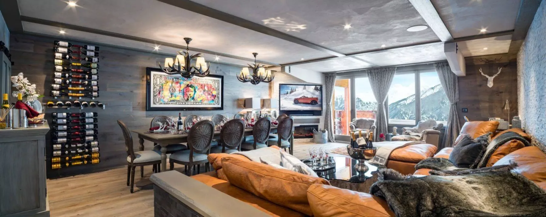 A spacious living and dining room with seating, a table, and large windows.
