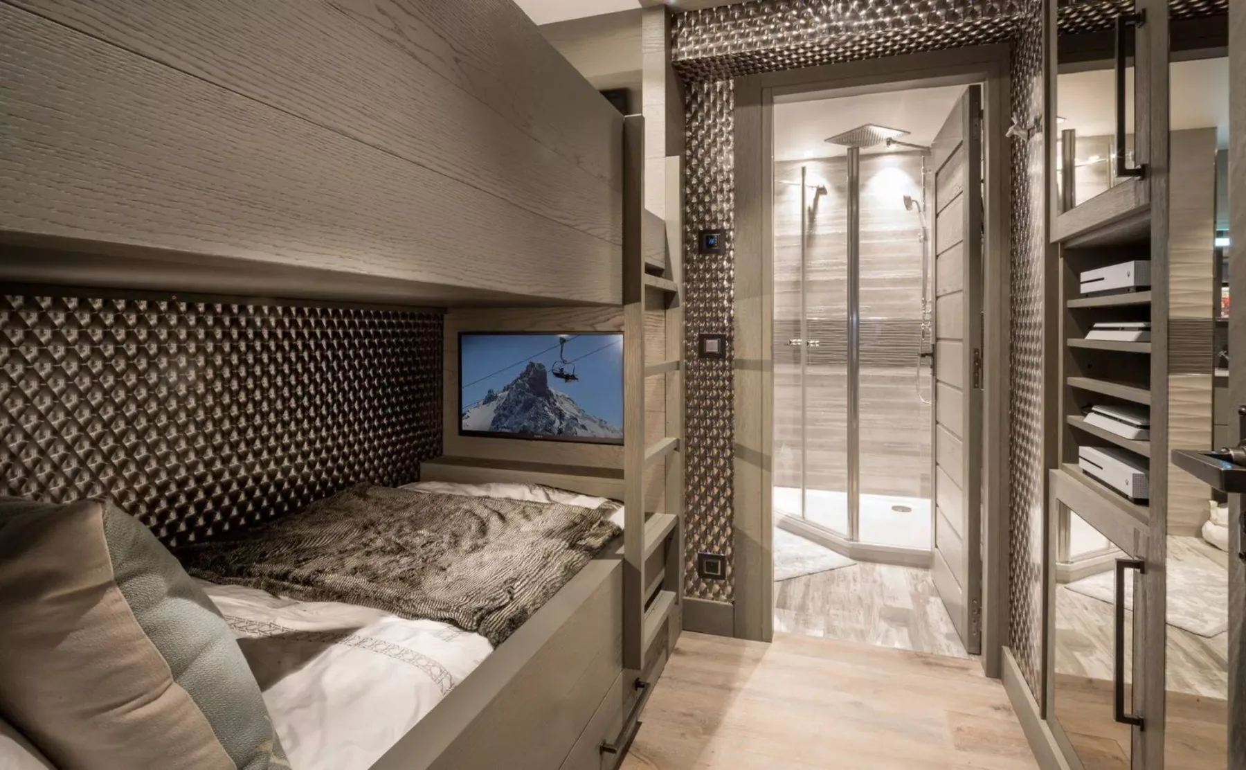 Un dormitorio pequeño con una cama junto a una ducha acristalada.