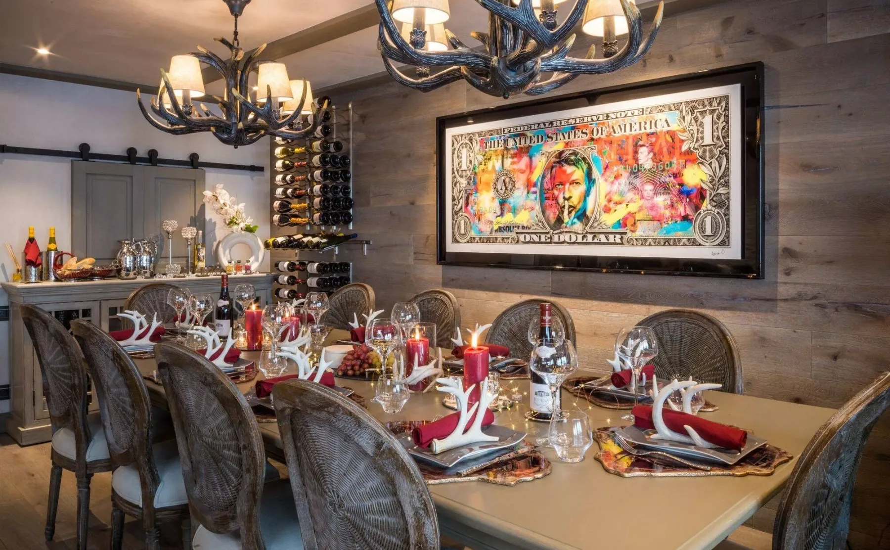 A dining room with a long table set with red napkins and glassware.