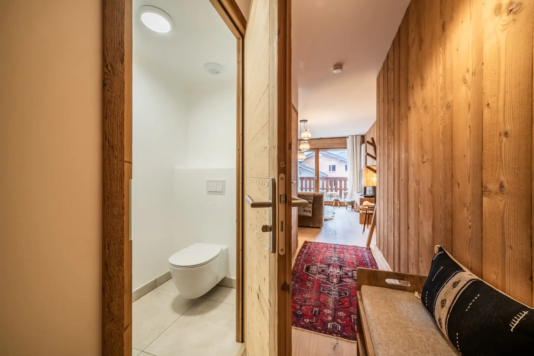 A bathroom with wooden walls and a toilet.