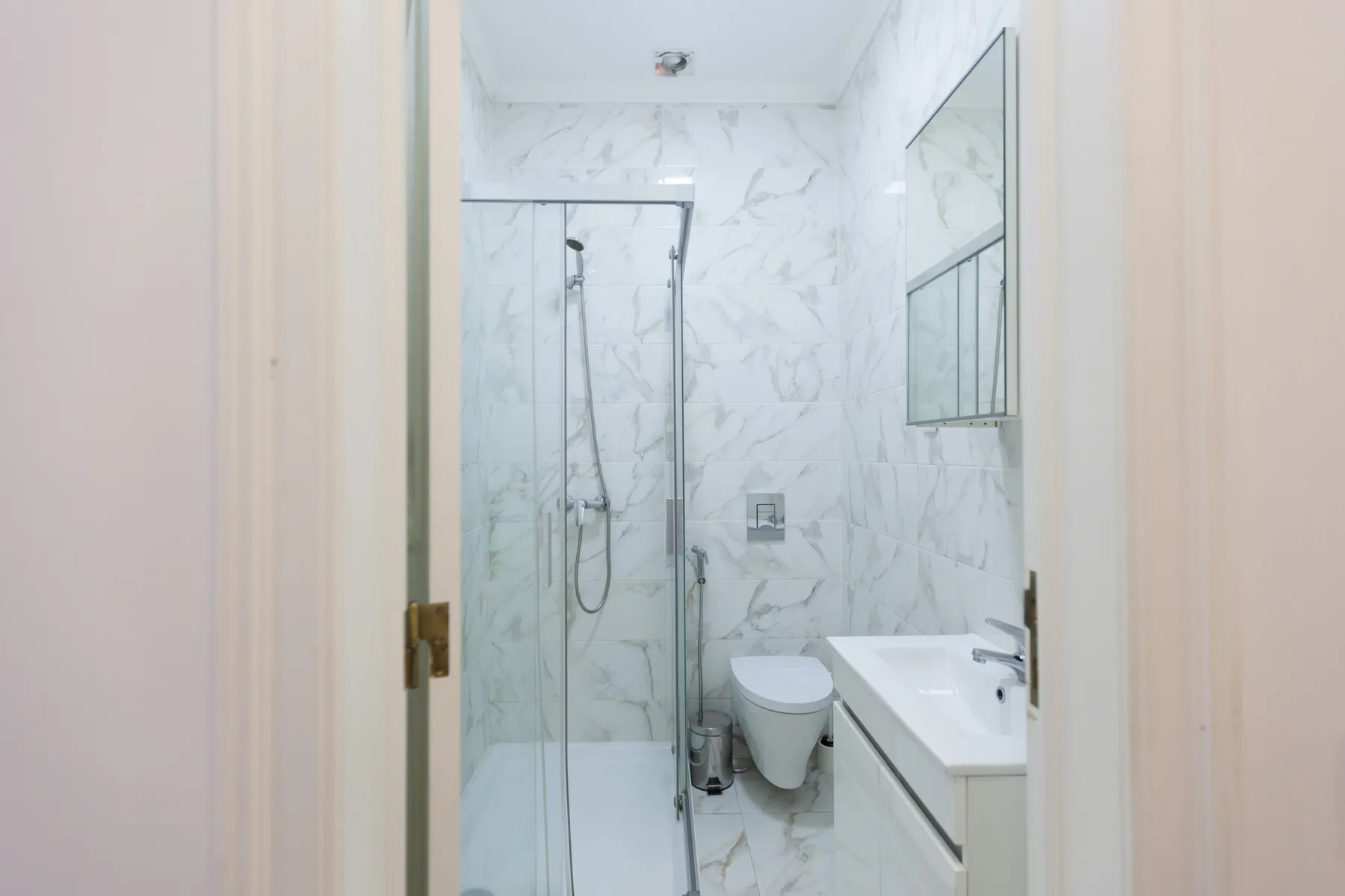 A bathroom with a glass shower and a sink.