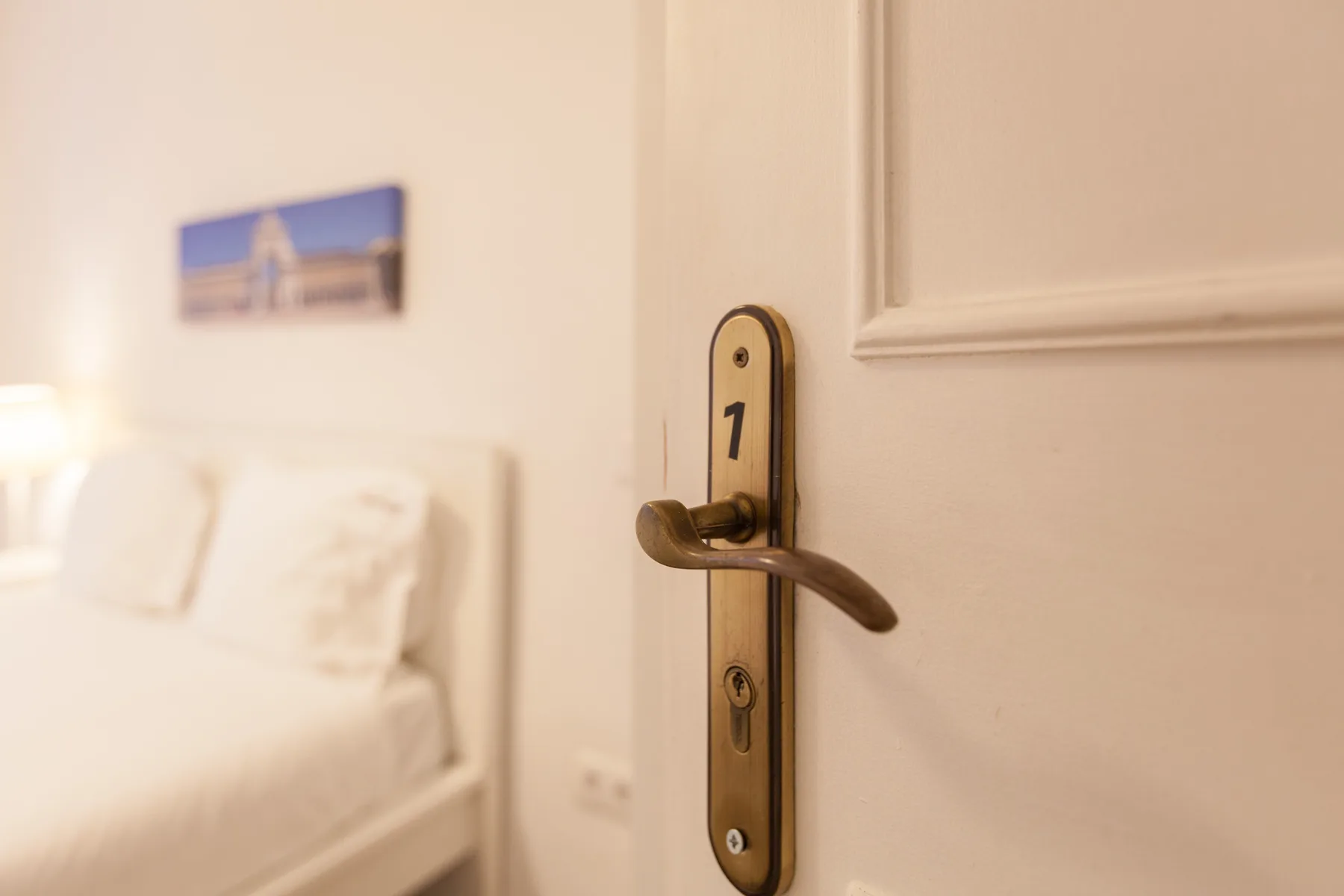 A bedroom is visible through a partly open door with the number 1.