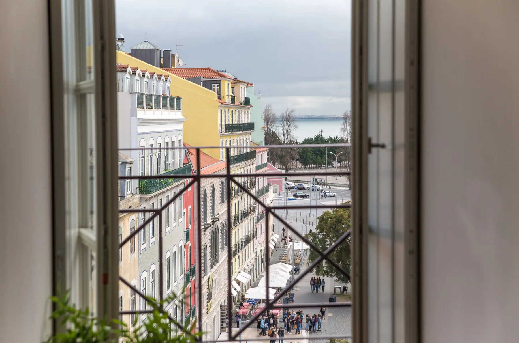 A window overlooks colorful buildings and a waterfront promenade.