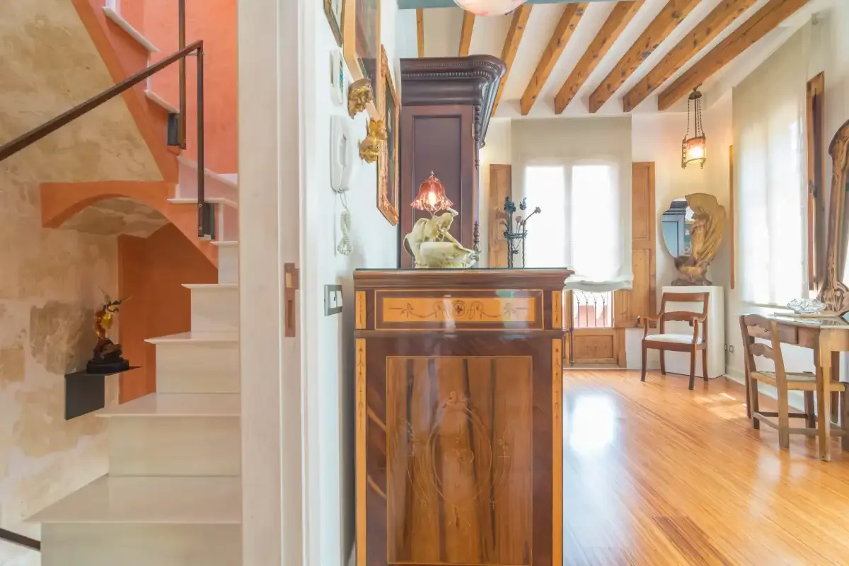 A bright dining room with a wooden table and a staircase.