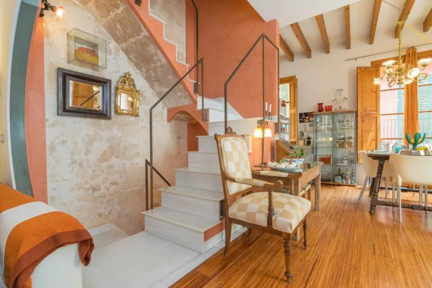 An open living and dining area features a staircase and a dining table.