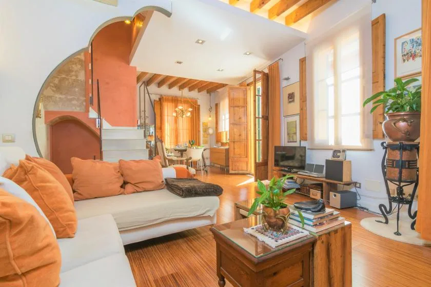 A bright living room with cushioned seating and a wooden coffee table.