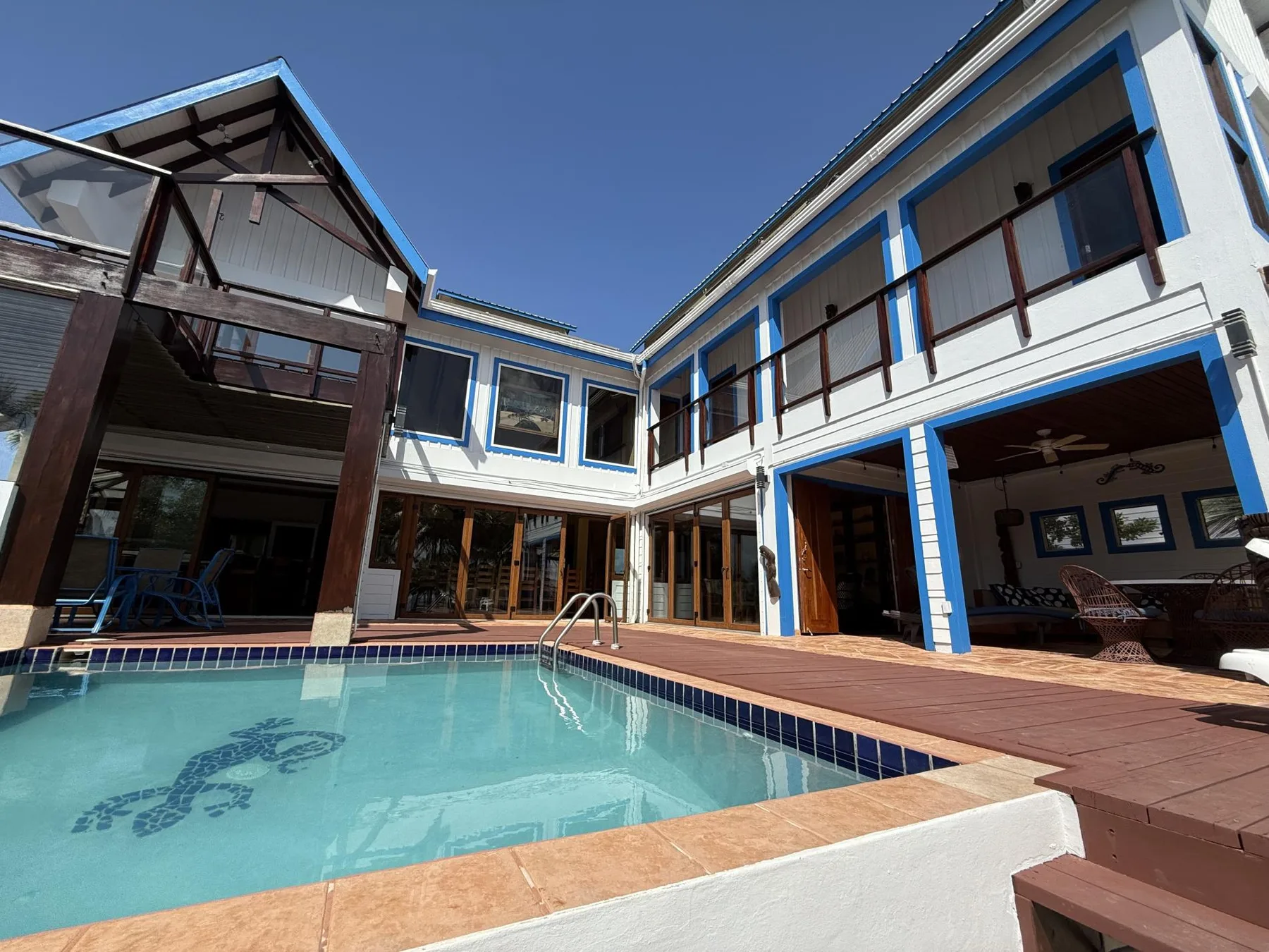 A courtyard pool sits beside a two-story building with balconies.