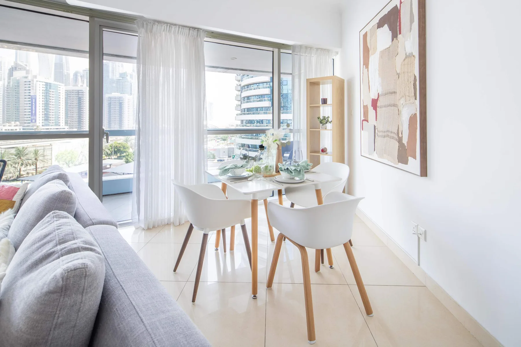 Un comedor luminoso con una mesa y asientos junto a grandes ventanales.