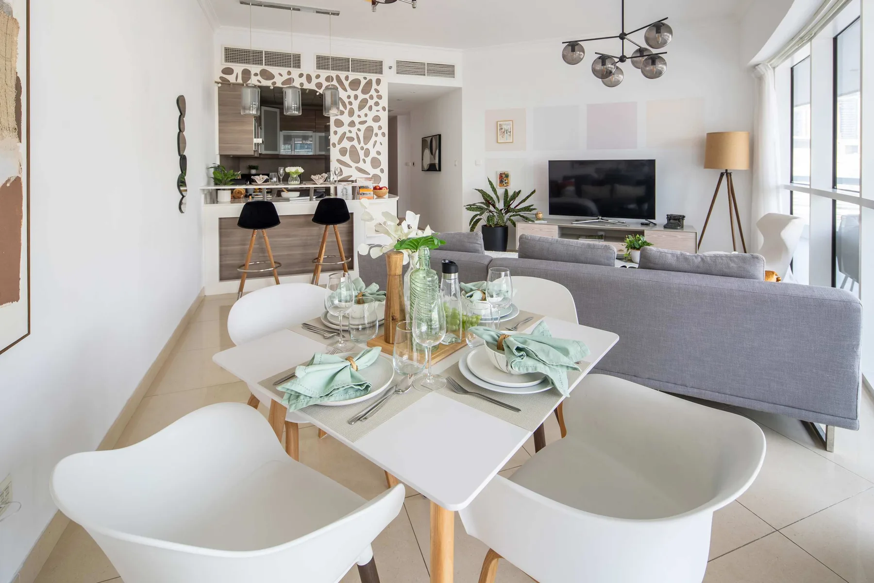 Una sala-comedor de planta abierta con la mesa puesta y un televisor.