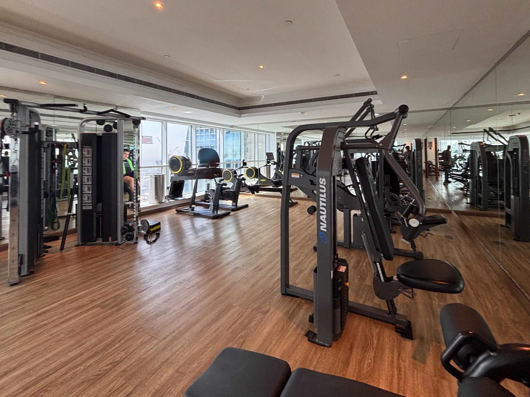 Una sala de ejercicios con máquinas y grandes ventanas.