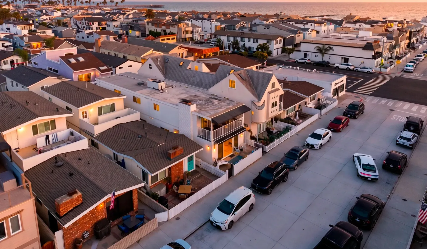 Vista aérea de un vecindario costero con casas y una calle junto al océano.