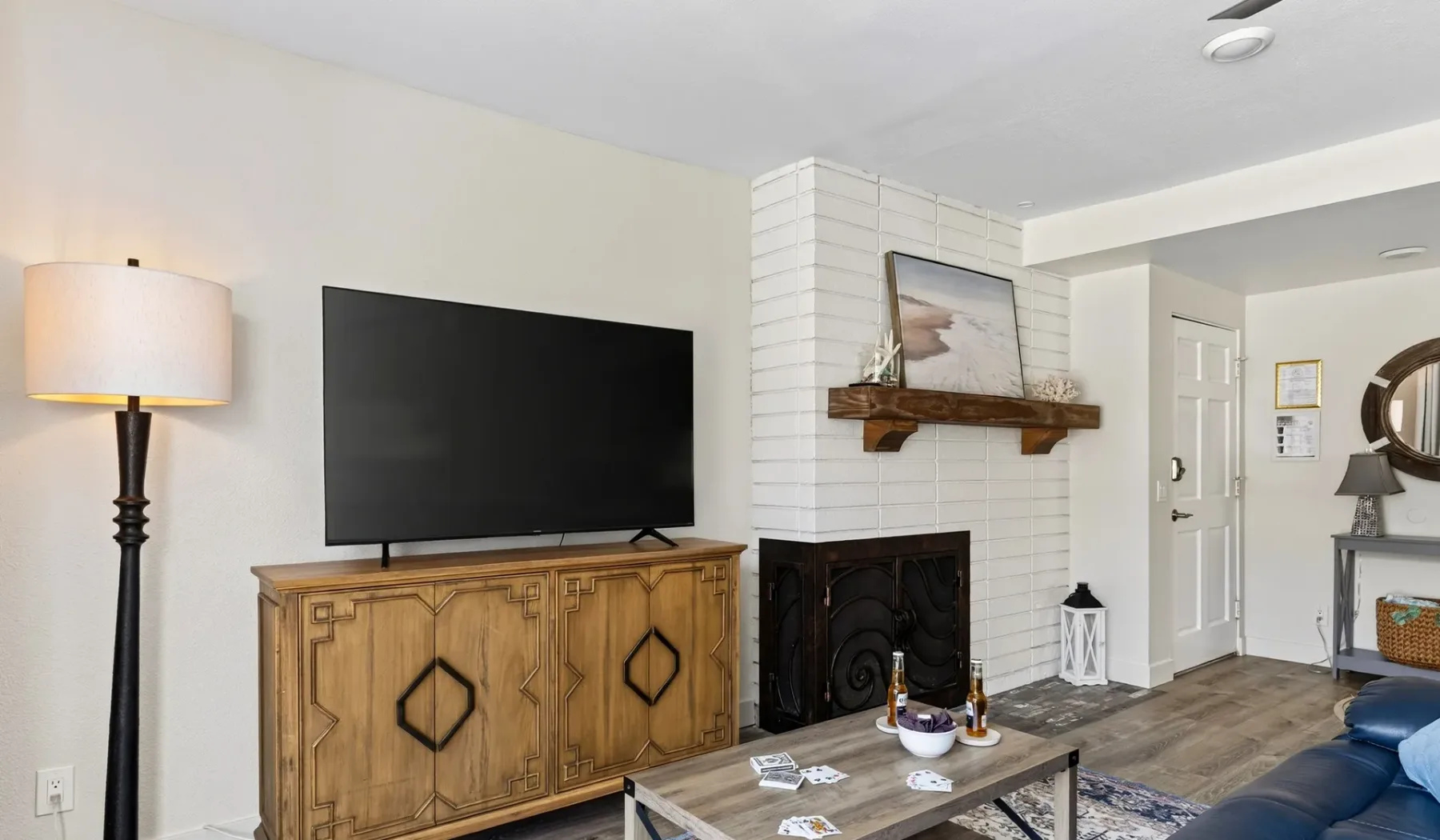 Una sala de estar con un televisor sobre un mueble de madera y una chimenea.