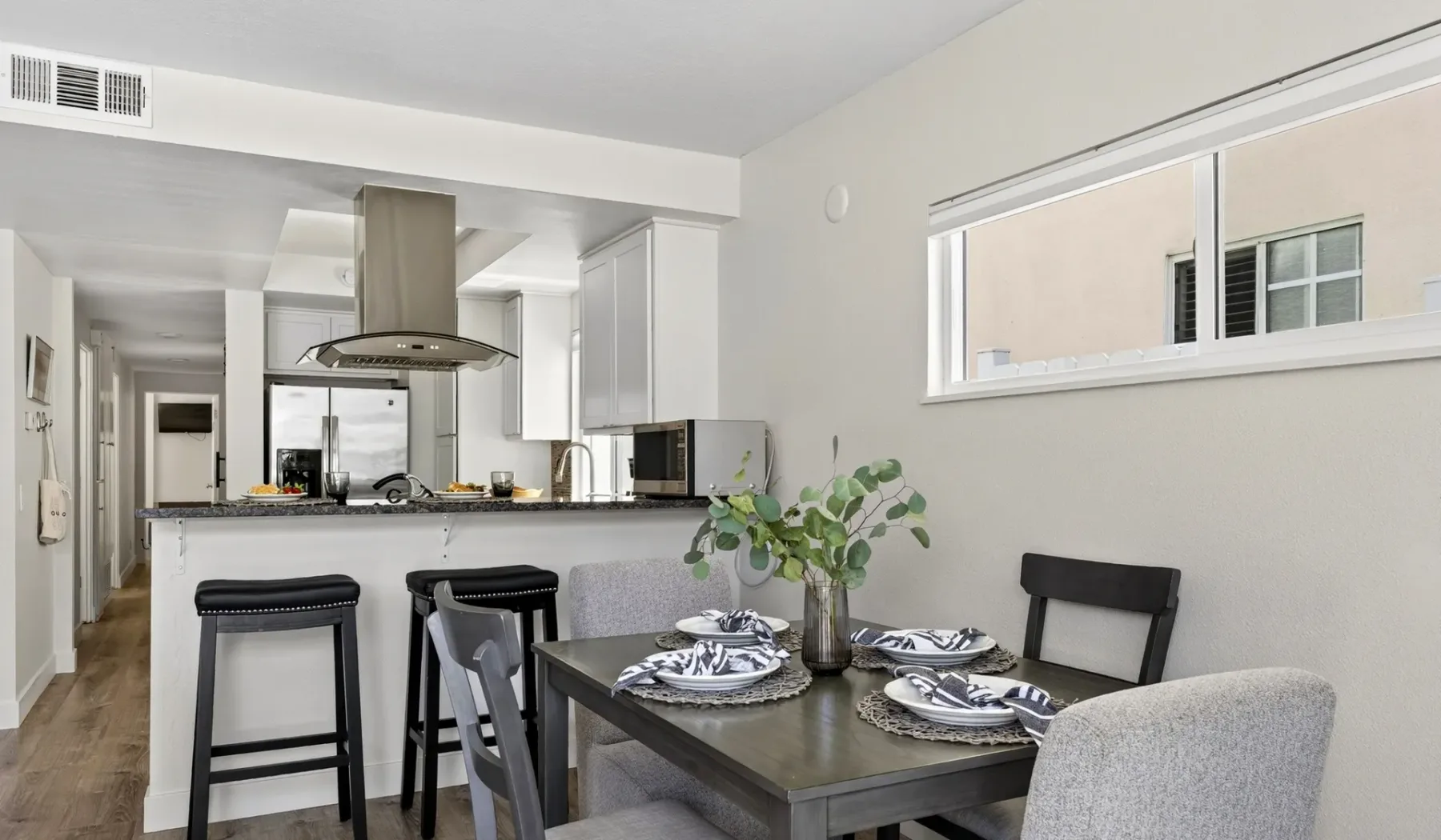 Un comedor de concepto abierto con la mesa puesta junto a la cocina.