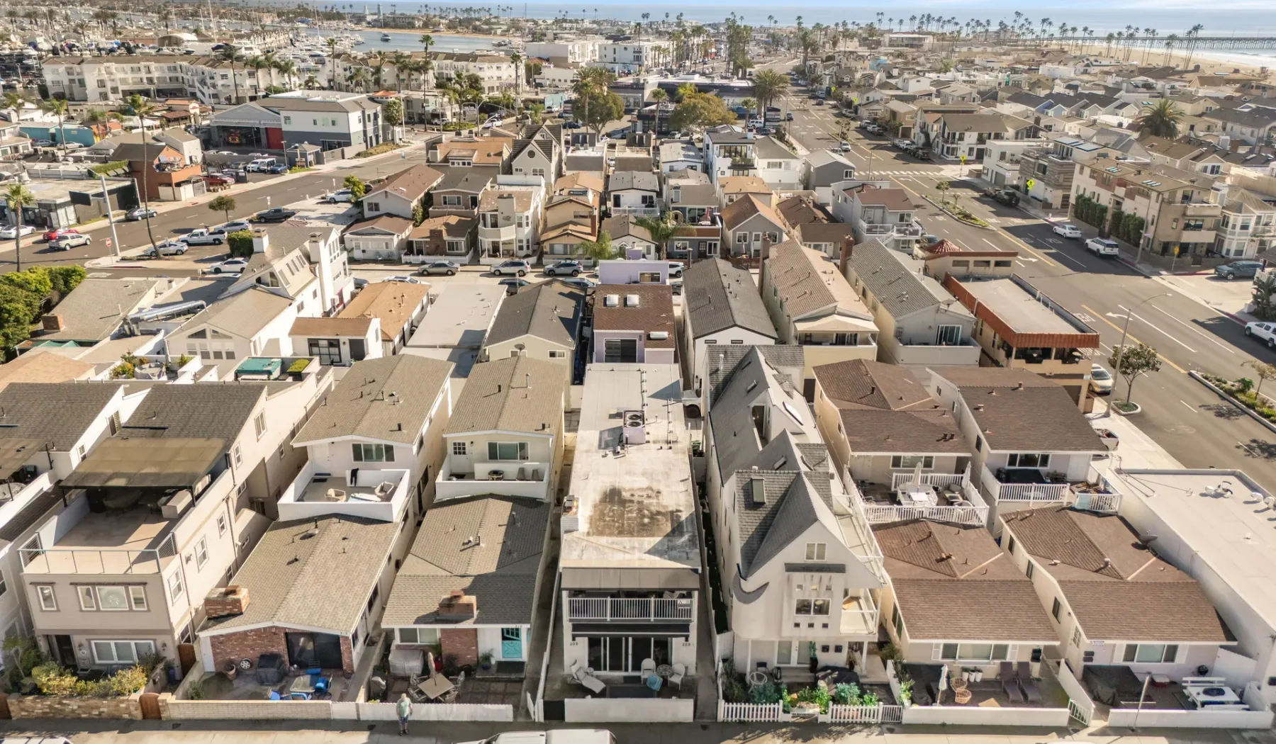 Vista aérea de un vecindario costero con hileras de viviendas y calles.
