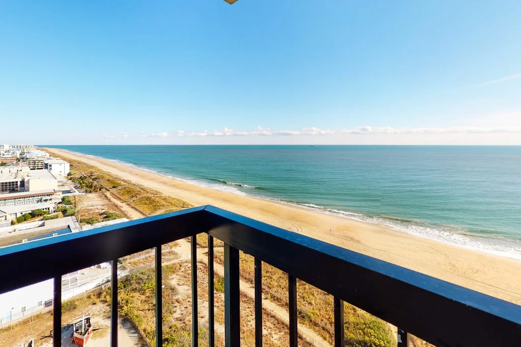 A balcony overlooks a sandy beach and the open sea.