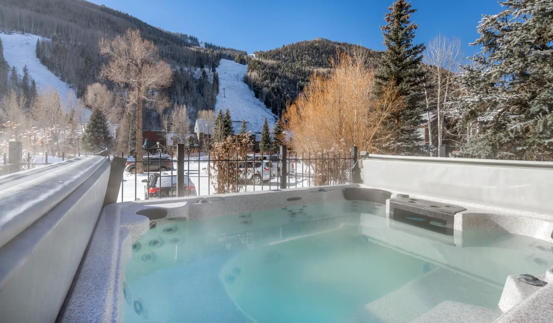 Una bañera de hidromasaje al aire libre ofrece vistas a un paisaje montañoso nevado.