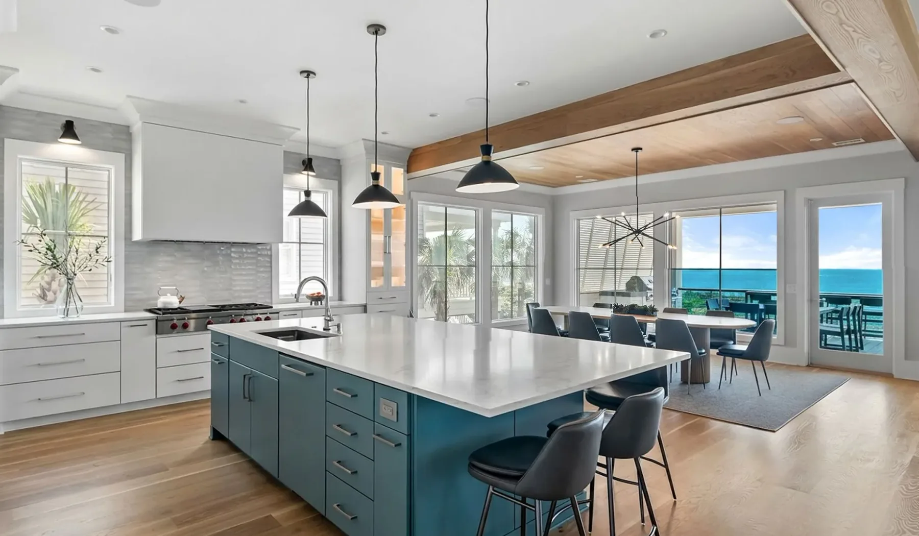 Una luminosa cocina abierta al comedor, con grandes ventanales y vistas al agua.