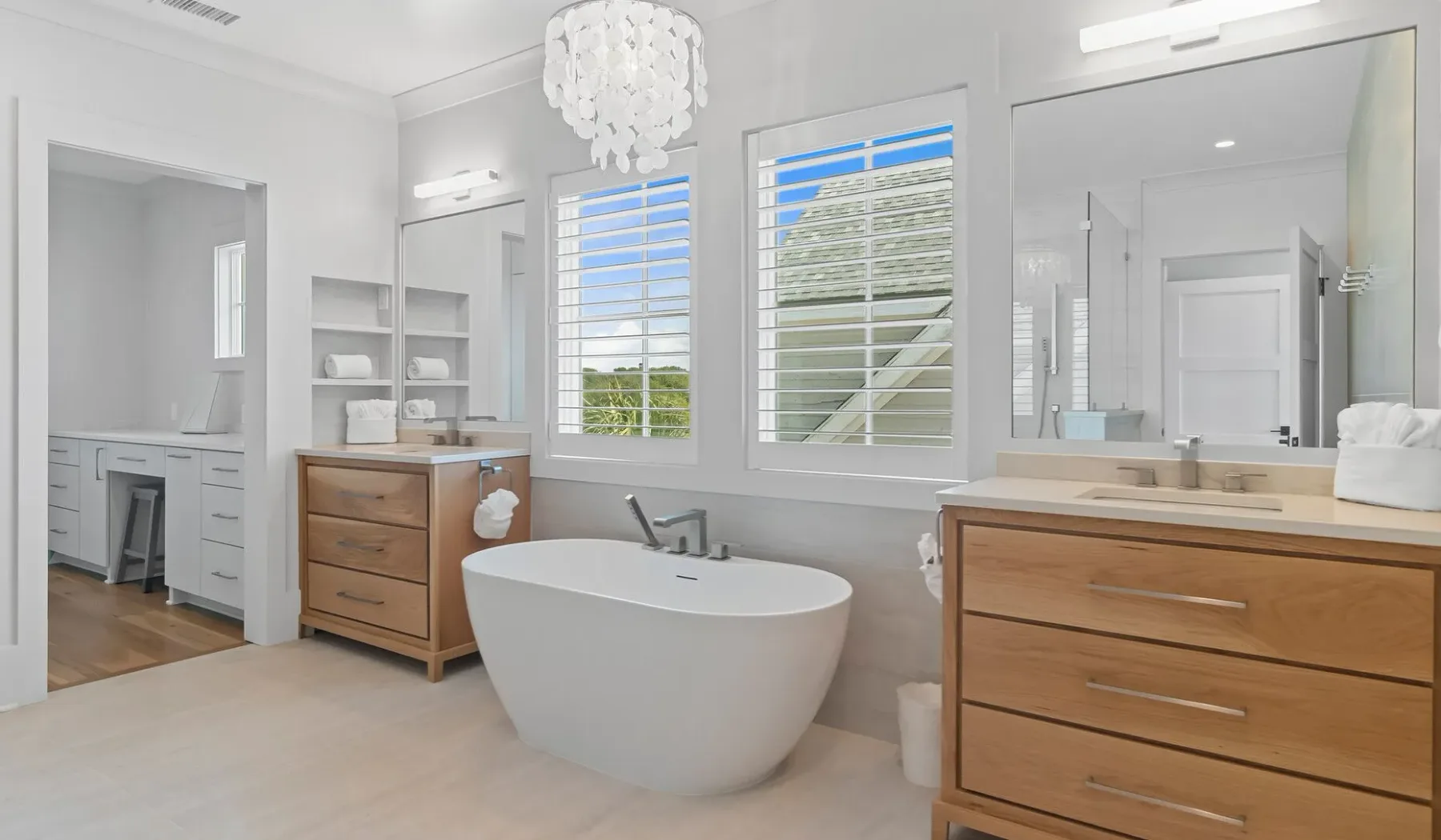 Un baño luminoso con bañera exenta, tocador y ventanas grandes.