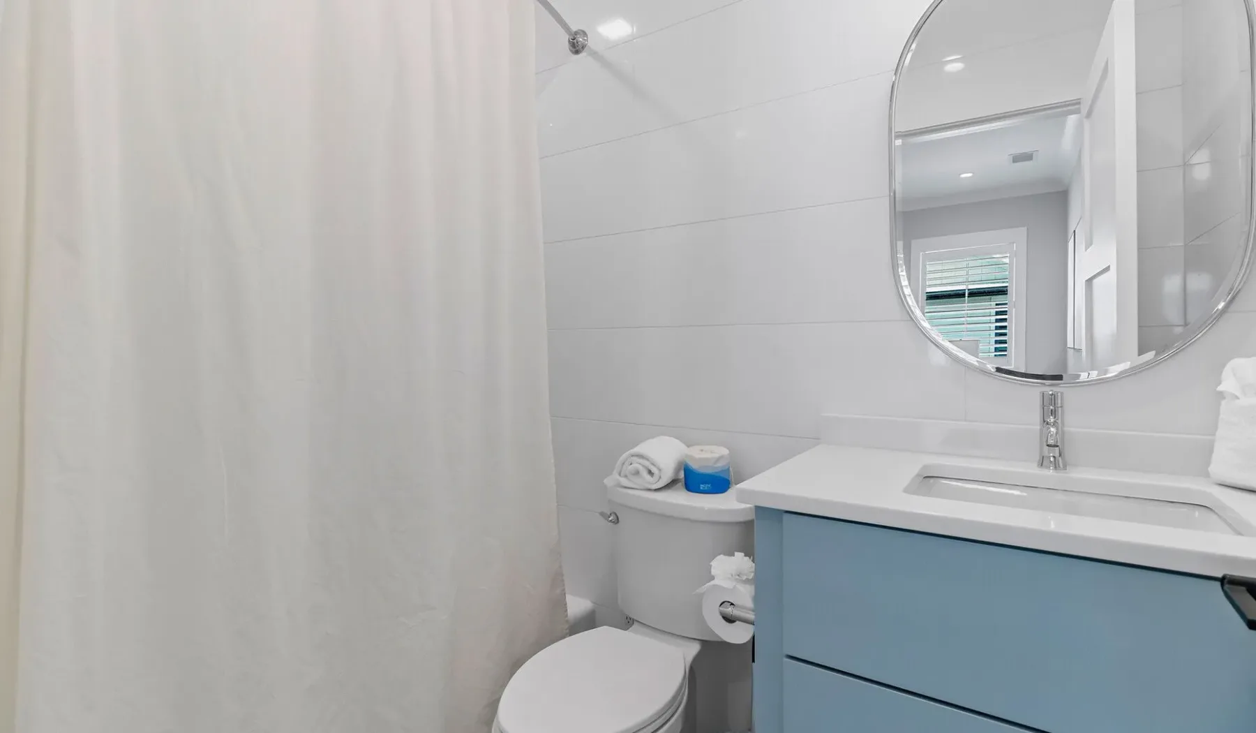Un baño con cortina de ducha, inodoro y lavabo.