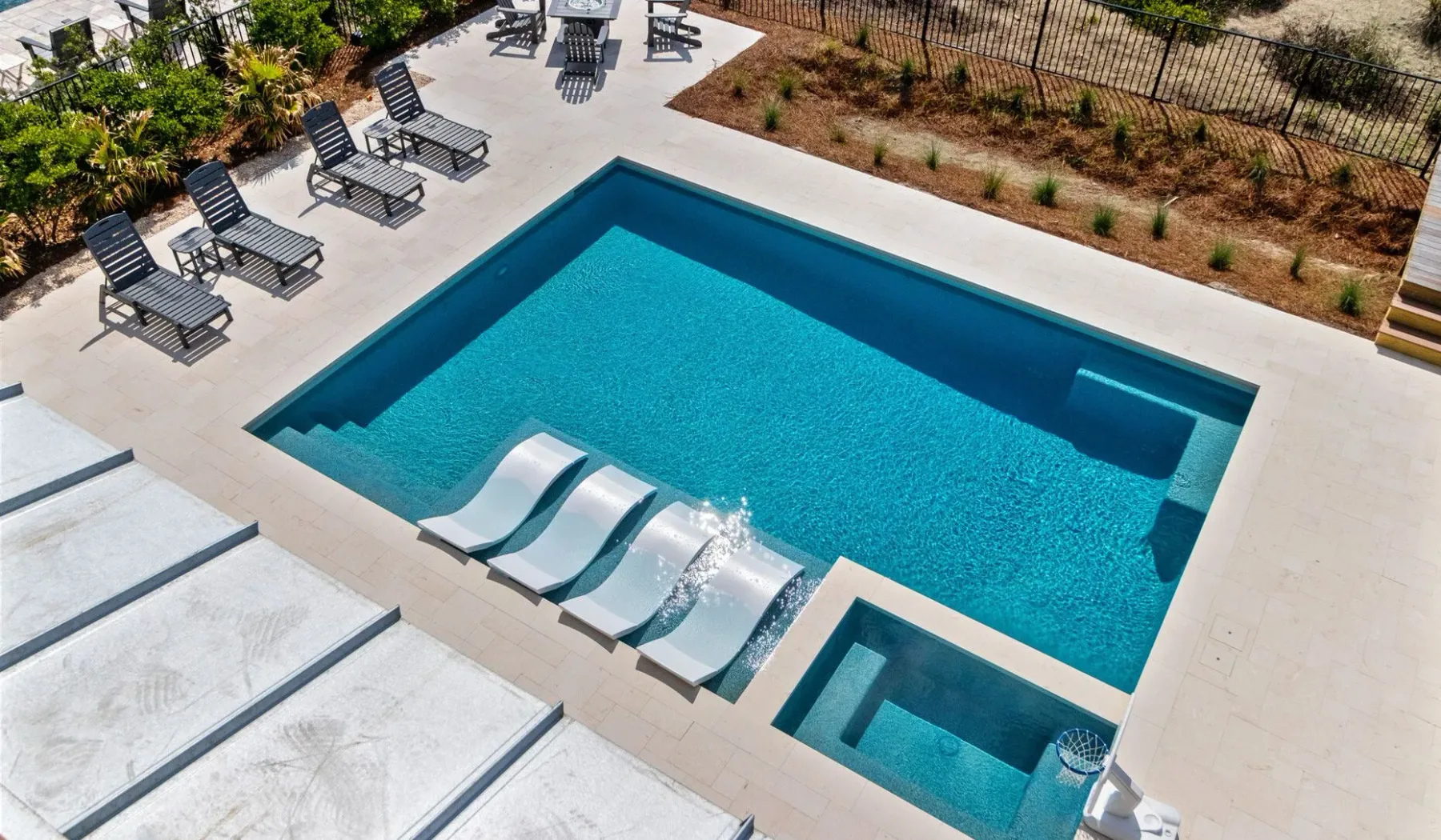 Una piscina al aire libre con tumbonas y una zona poco profunda.