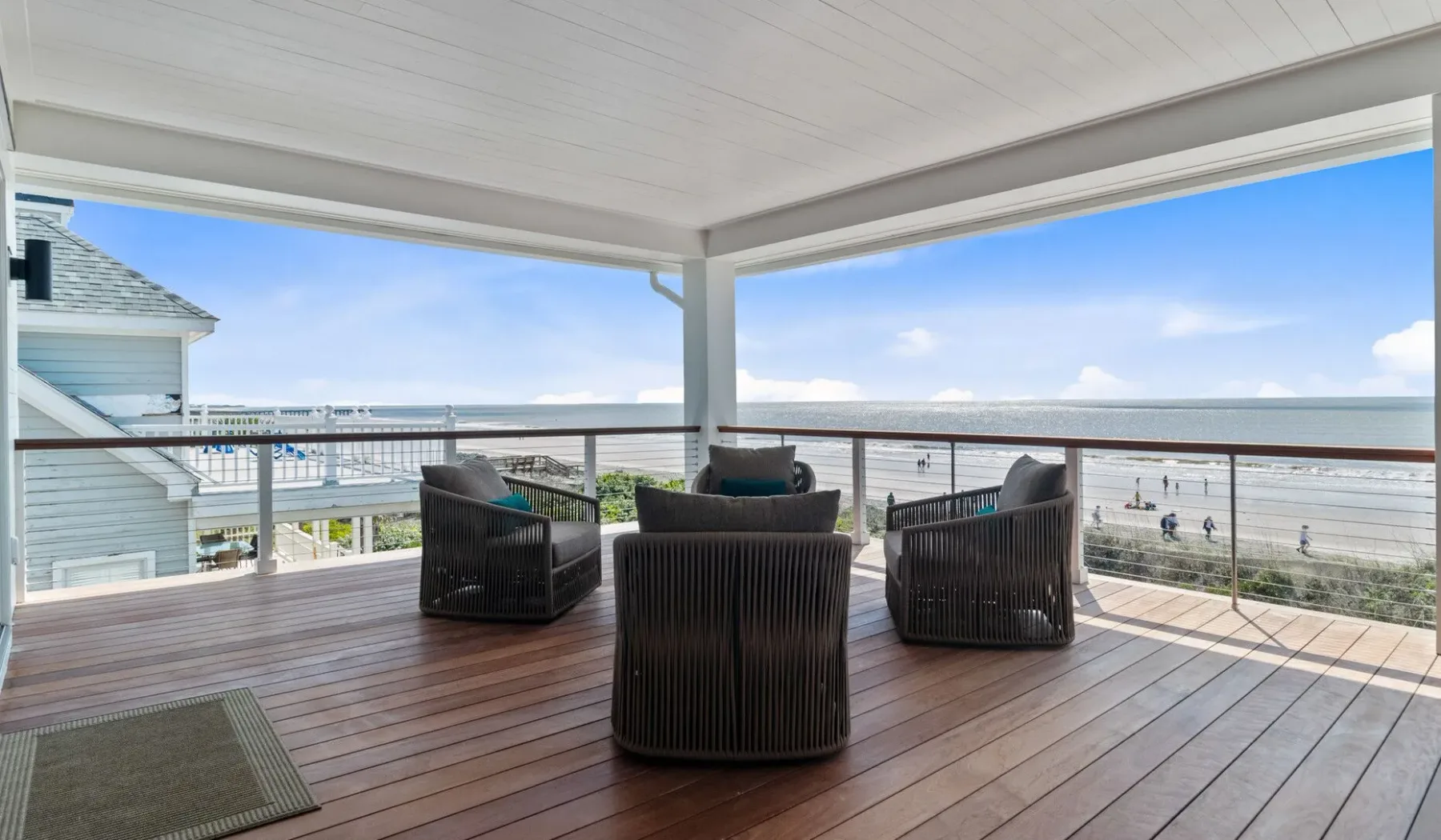 Una terraza cubierta con asientos al aire libre da a la playa y al océano.