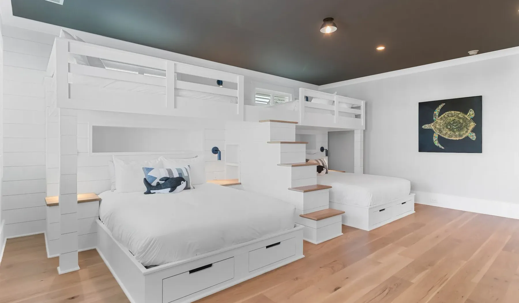 Un dormitorio blanco con dos camas bajo literas integradas.