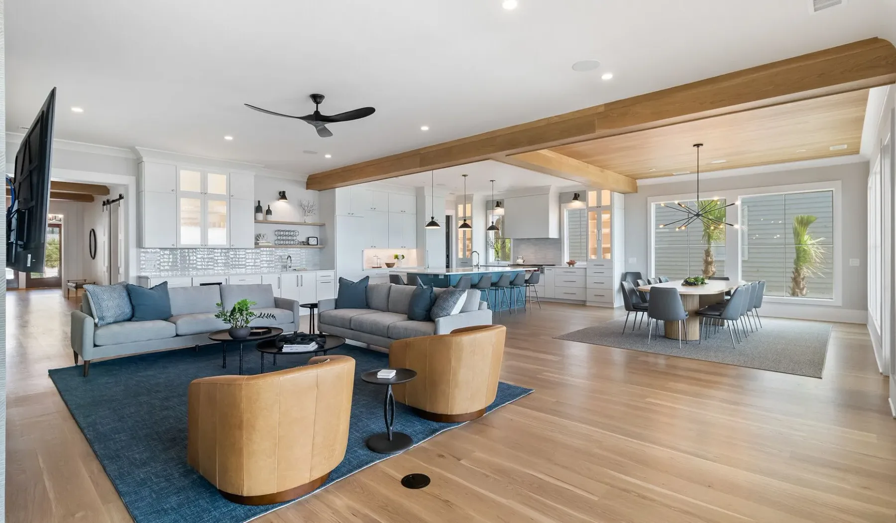 Una sala y comedor de concepto abierto con asientos, cocina y ventanales.