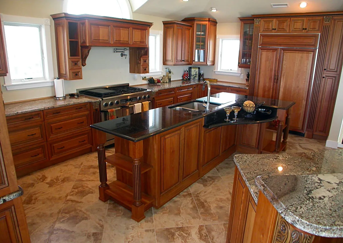 Una cocina amplia con gabinetes de madera y una isla central con encimera oscura.