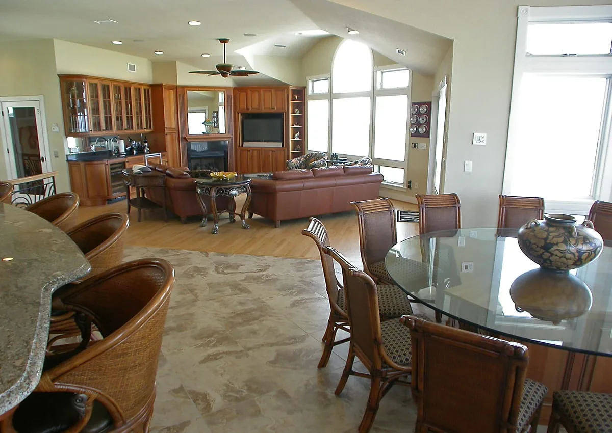 Una sala-comedor de concepto abierto con muebles de madera y ventanas grandes.