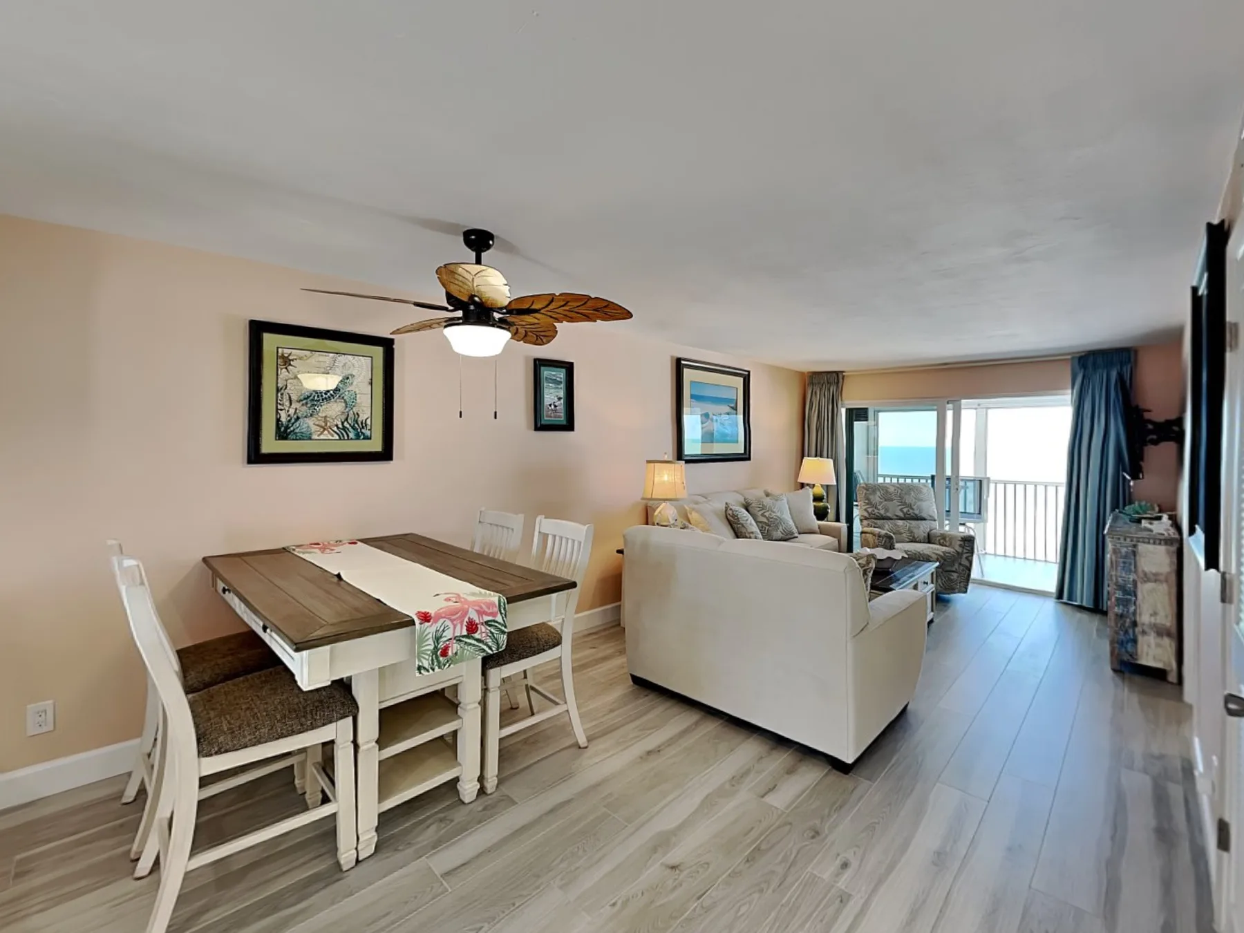 An open living and dining area with a table, seating, and sliding glass doors.