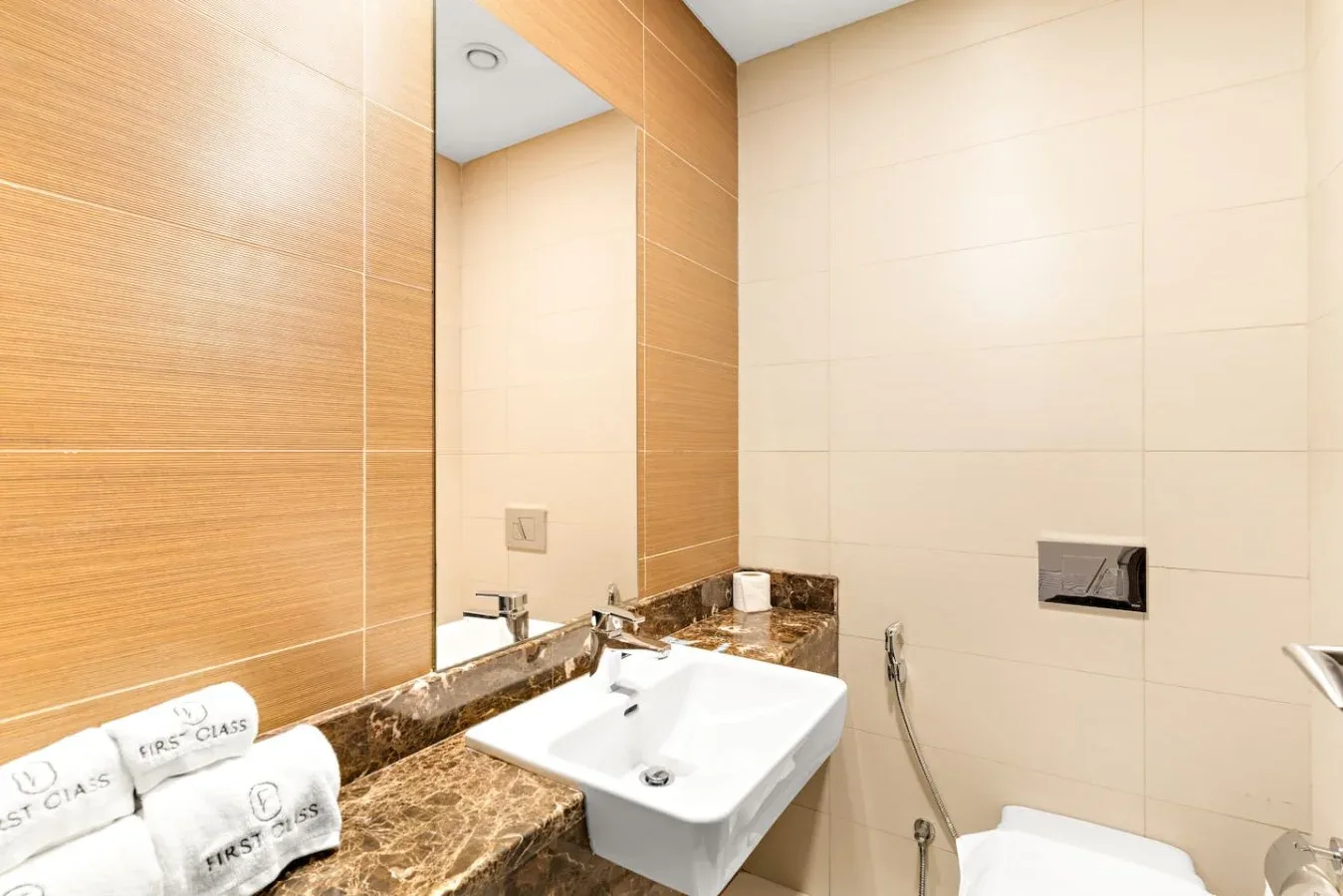 A bathroom with a white sink and large wall mirror.