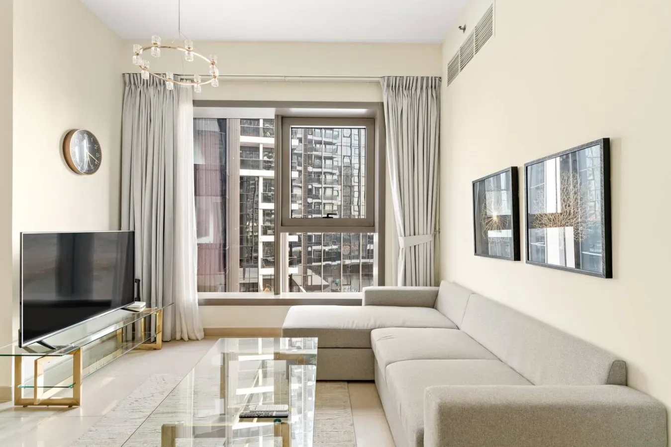 A bright living room with floor-to-ceiling windows and a sectional sofa.