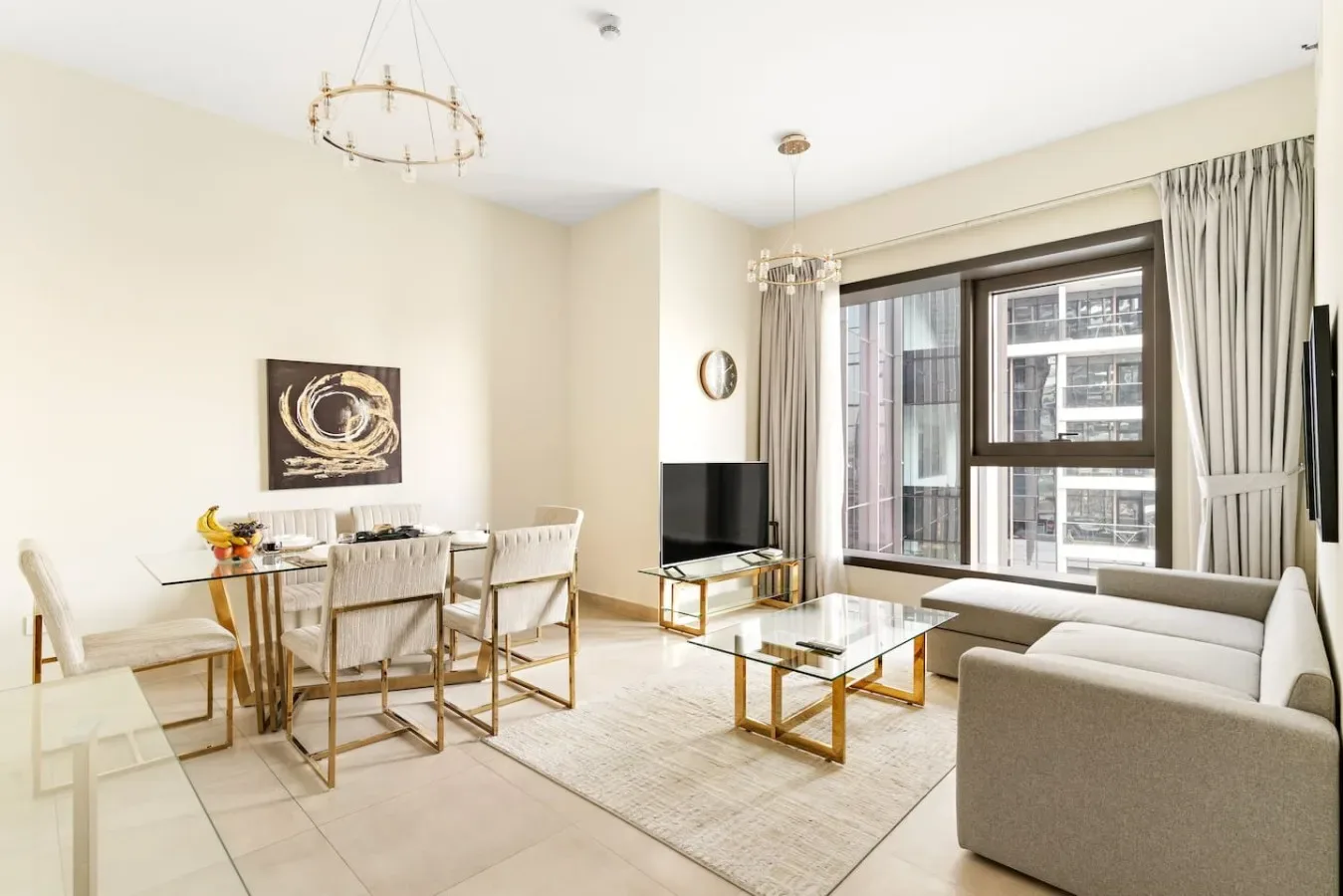 A bright living and dining room with seating, a dining table, and large windows.