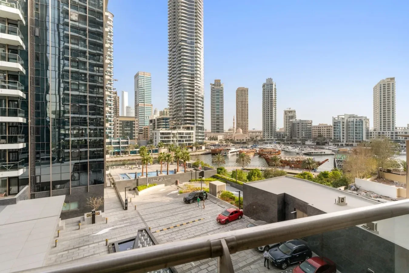 A cityscape of high-rise buildings overlooks a landscaped waterfront plaza.