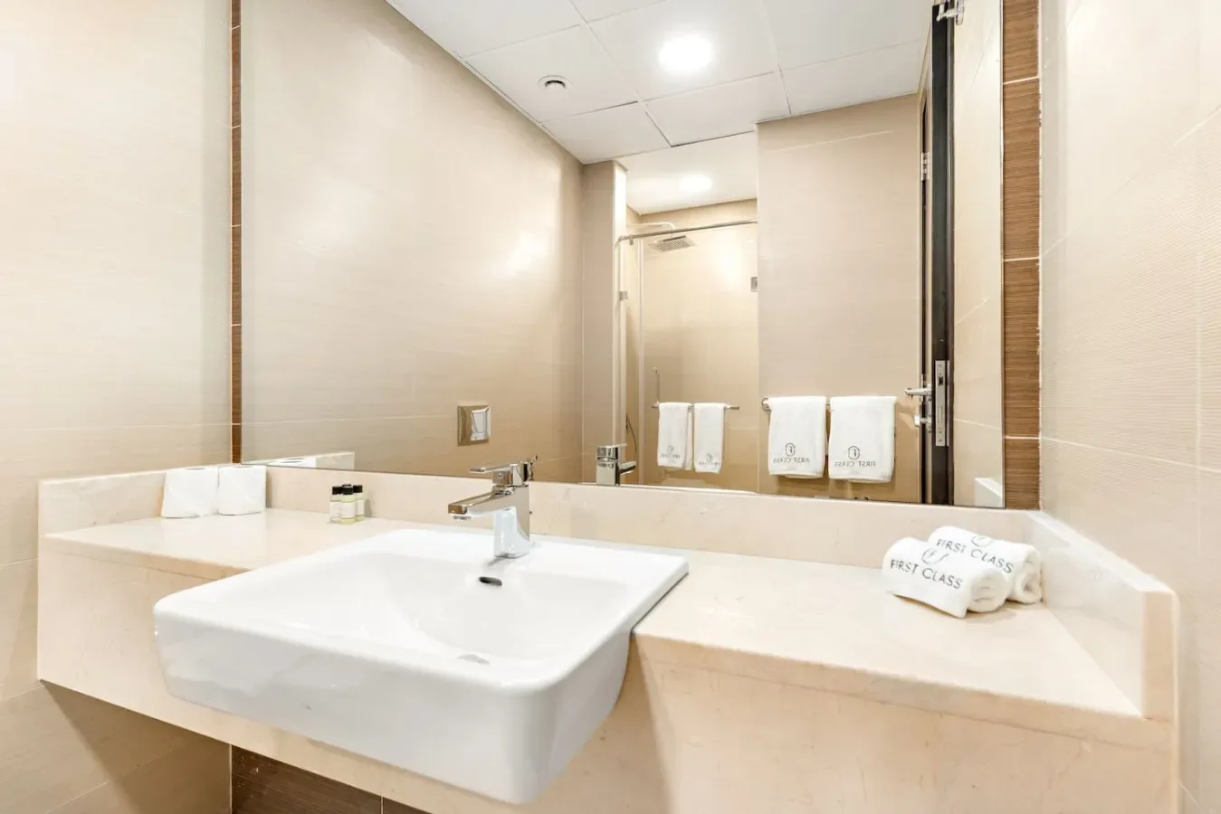 Bathroom vanity with a wide mirror and a white sink.