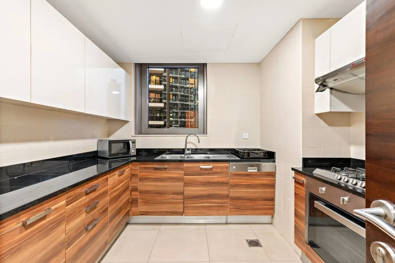 A modern kitchen with wood-toned cabinets and a window above the sink.