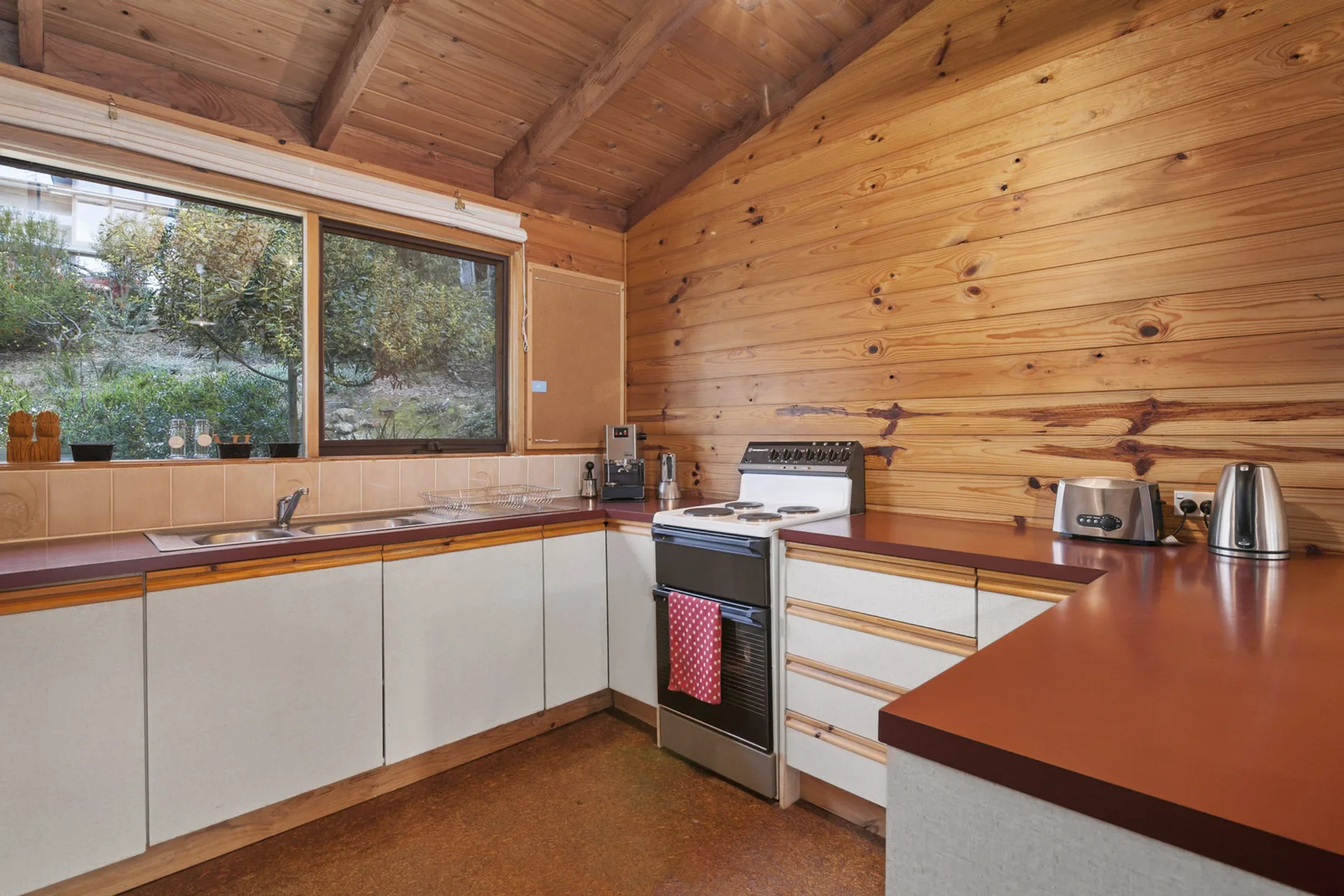 Una cocina con paredes revestidas de madera y encimeras.