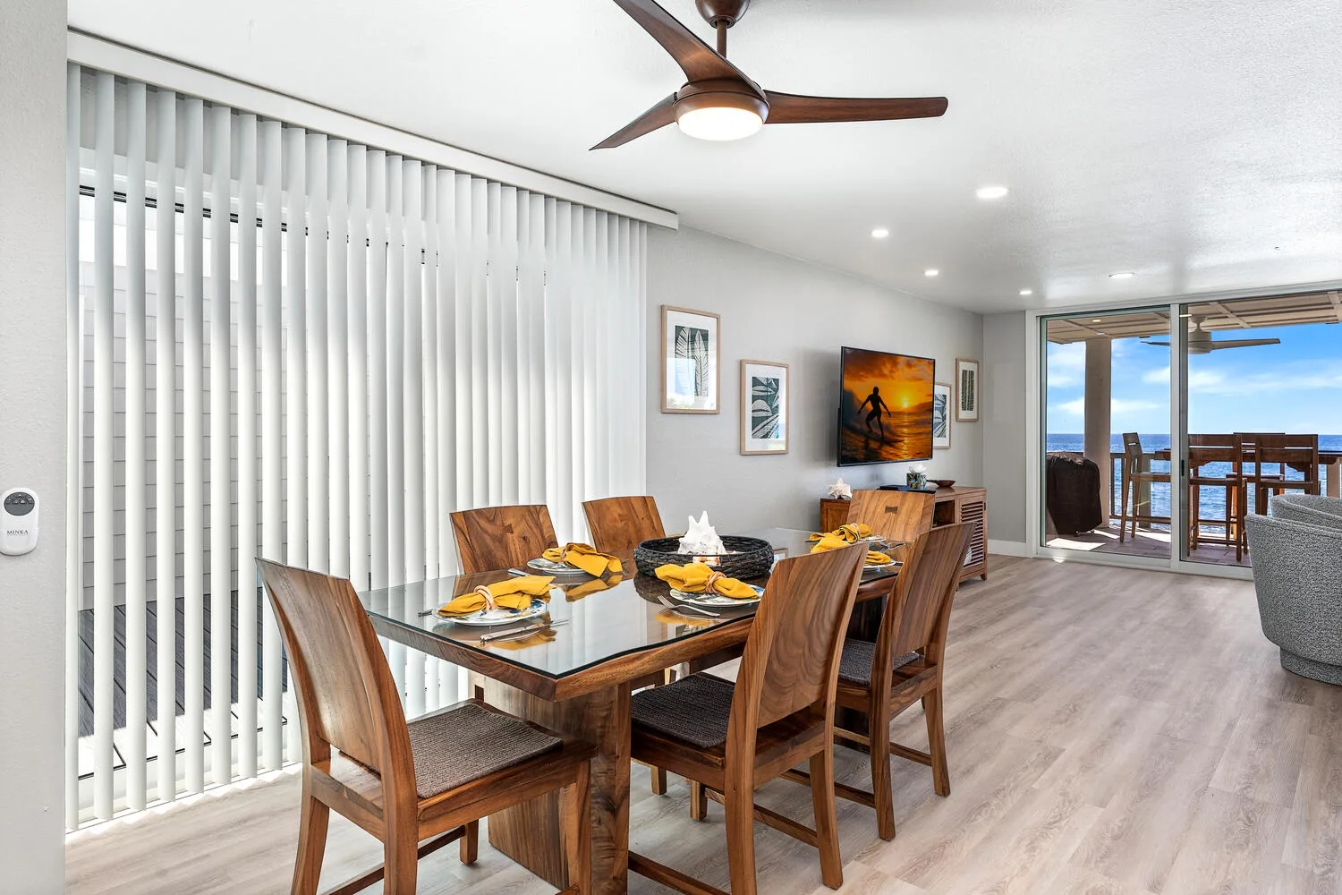Comedor con una mesa de madera y sillas junto a puertas corredizas de vidrio.