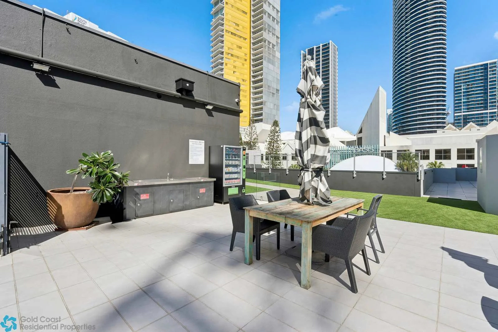 Un patio exterior con una mesa de comedor y asientos junto al césped.